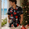Man wearing a festive black shirt with red and white patterns, standing by a Christmas tree and ocean view.