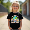 Child wearing a black t-shirt with 'Harmony Day Everyone Belongs' design outdoors.