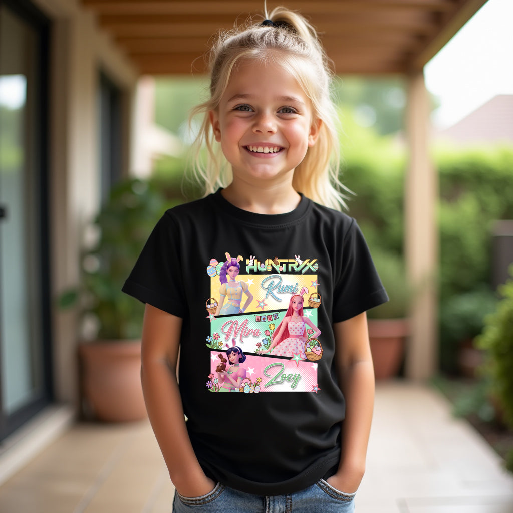 Child wearing a easter kpop black t-shirt with colorful graphics and text outdoors.