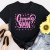 Pregnant woman wearing “Coming Soon” maternity shirt for pregnancy reveal or photo shoot.