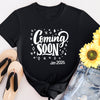 White t-shirt with “Coming Soon” text design, styled for pregnancy announcements and maternity wear.