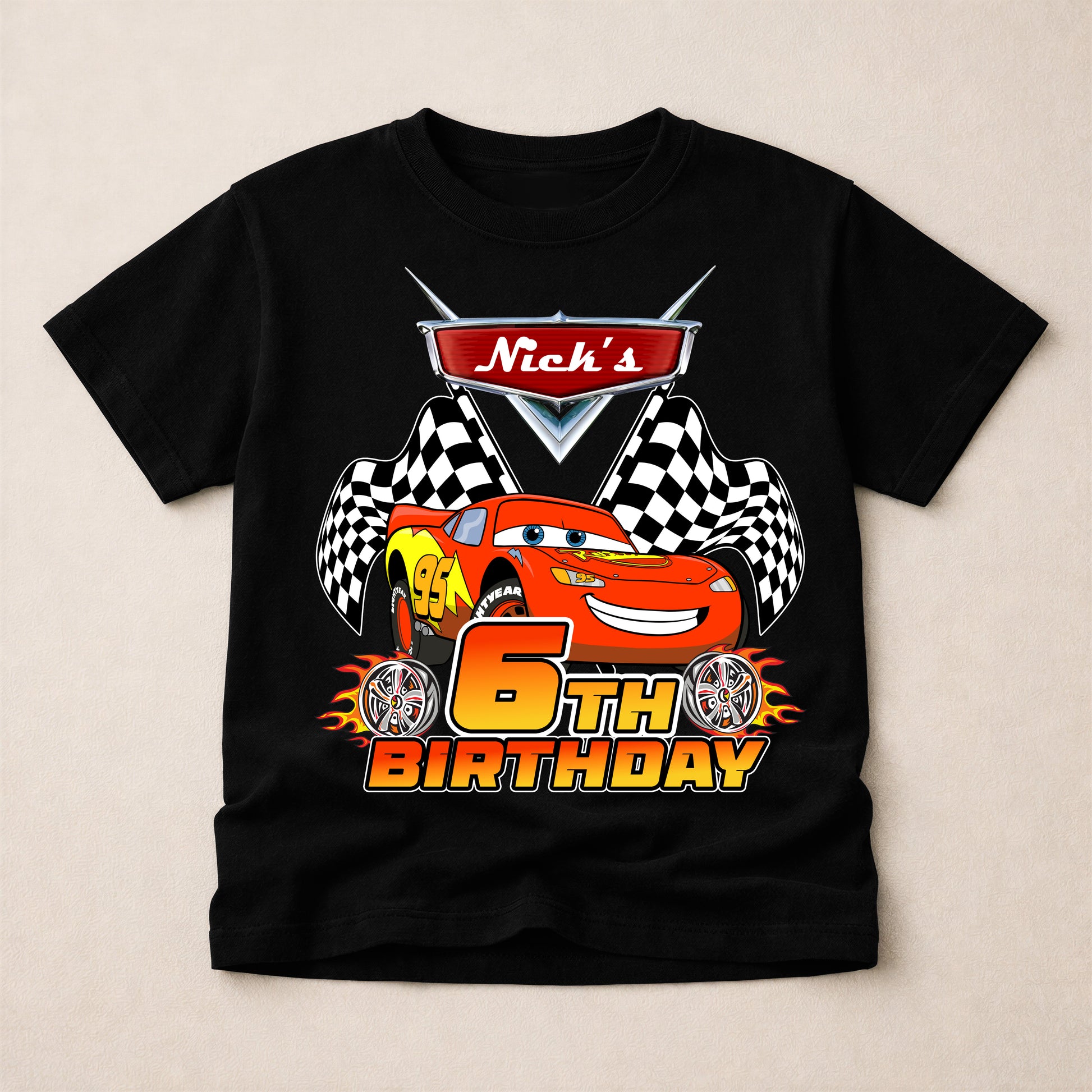 Black t-shirt with a cartoon car design and 'Nick's 6th Birthday' text on a beige background