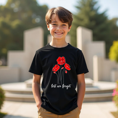 Child wearing a black t-shirt with red poppy design and 'lest we forget' text outdoors.