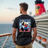 Man wearing a black t-shirt with a colorful graphic design on a cruise ship deck.