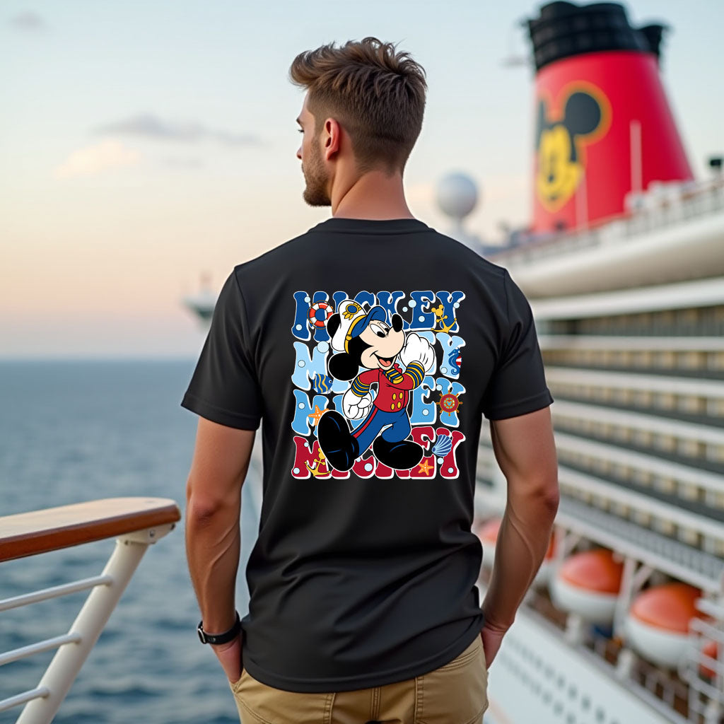 Man wearing a black t-shirt with a colorful graphic design on a cruise ship deck.