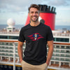 Man wearing a black t-shirt with a colorful graphic design in front of a cruise ship.