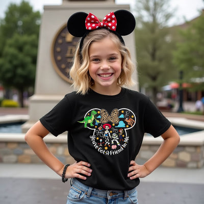 Young girl wearing a black t-shirt with colorful graphics and text, standing outdoors.