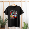 Black t-shirt with colorful Disney character design on a hanger against a light background