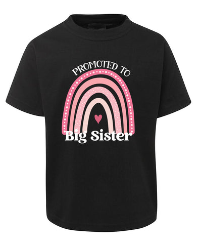 Black t-shirt with pink rainbow and heart design, text 'Promoted to Big Sister' on a white background