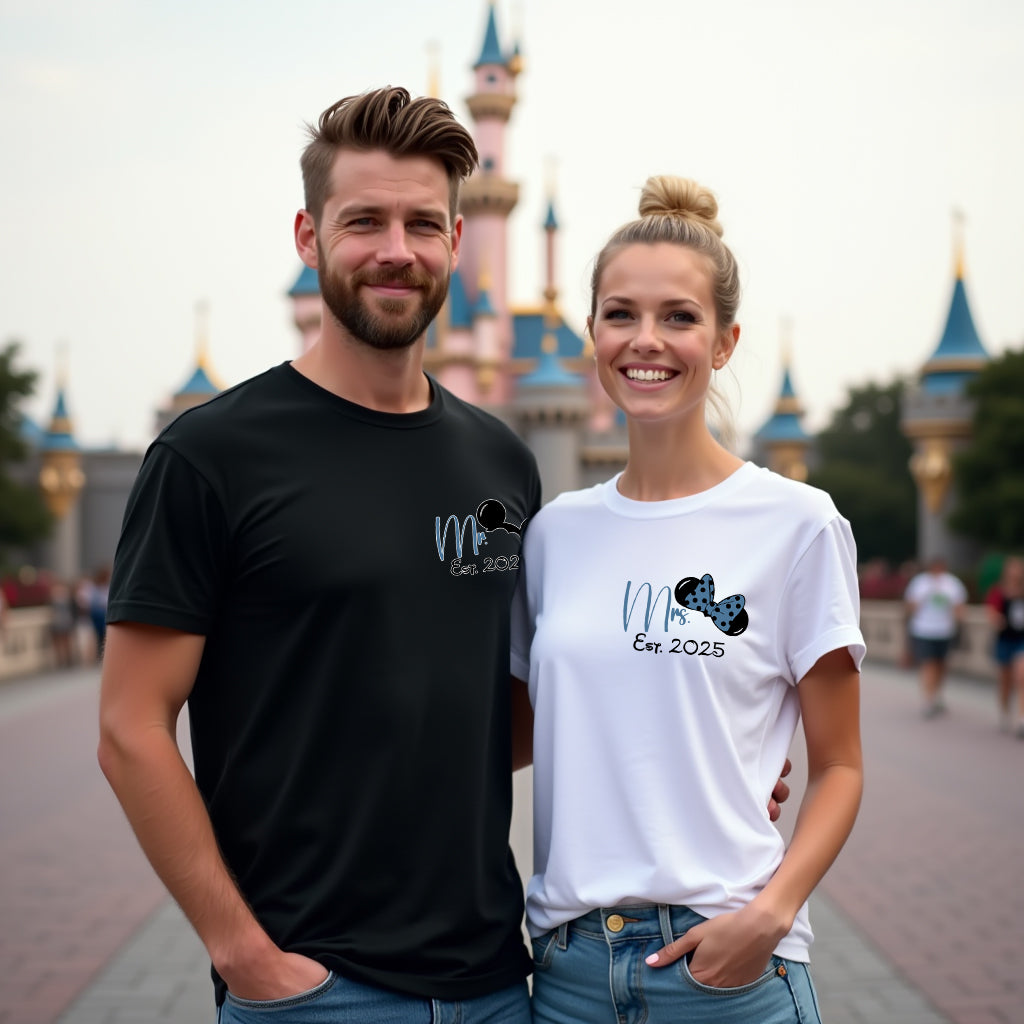 Man and woman standing together in front of a castle with matching t-shirts.