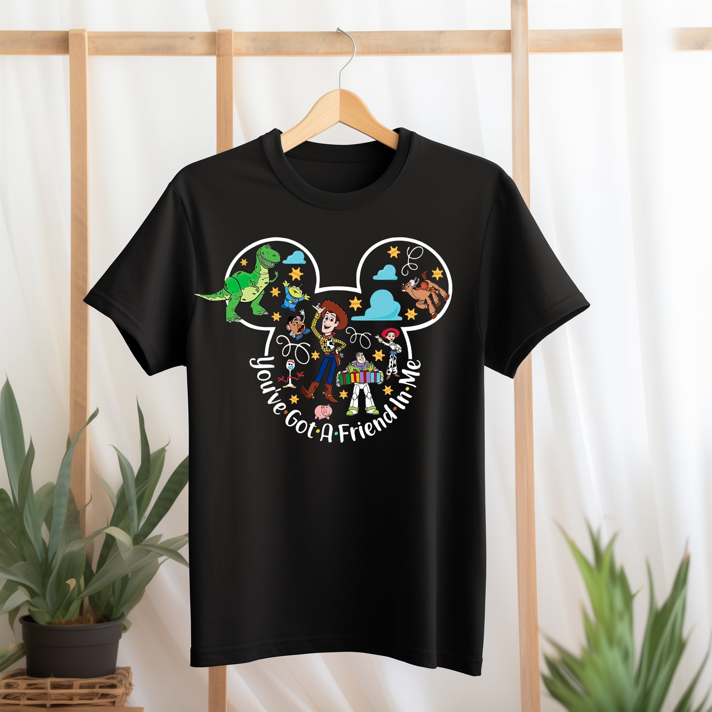 Black t-shirt with Disney character design and text on a hanger against a light background