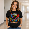 A woman smiling in a bright hallway wearing a black graphic t-shirt that reads 'THIS IS MY BOOK WEEK COSTUME!' in colorful retro-style lettering with cartoon illustrations.