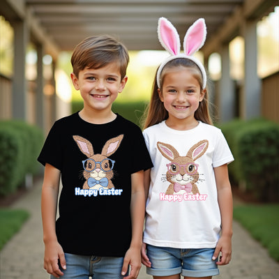 Two children wearing 'Happy Easter' t-shirts with bunny designs outdoors.