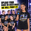 A smiling girl in a black t-shirt stands in a stage-like setting holding a phone that displays a custom graphic, with five other girls seated behind her wearing matching black t-shirts. Large text at the top reads, 'UPLOAD YOUR DANCE OR CHEER IMAGE WE WILL PRINT IT!'.