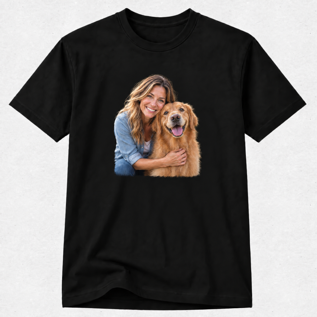 A black short-sleeve crewneck t-shirt featuring a custom graphic print of a smiling woman hugging a golden retriever dog, displayed on a light gray textured background.