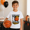 A smiling boy wearing a white graphic T-shirt and holding an orange basketball in a party setting with balloons, a birthday cake, and gift boxes in the background.