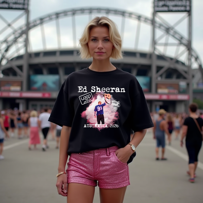 Person wearing a black t-shirt with Ed Sheeran graphic in front of a stadium.