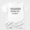 White t-shirt with 'WARNING Birthday Trip in progress' text on a white background