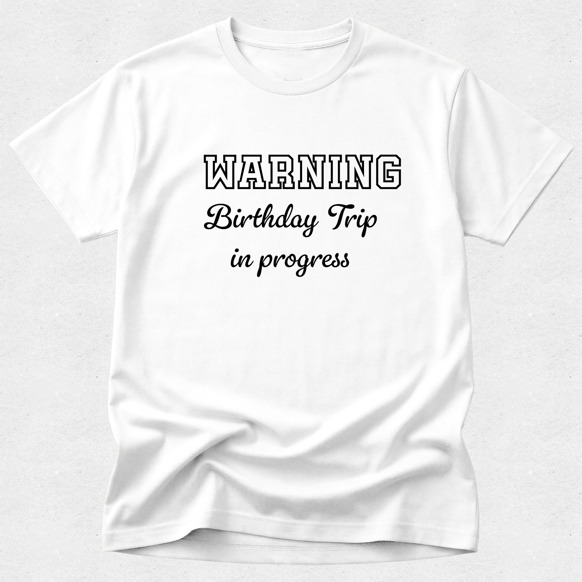 White t-shirt with 'WARNING Birthday Trip in progress' text on a white background