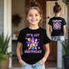 Child wearing a black t-shirt with 'It's My Birthday' design, standing indoors.