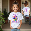 Young girl wearing a kpop white t-shirt with 'It's My Birthday' and character graphics, with a close-up inset of the back text.