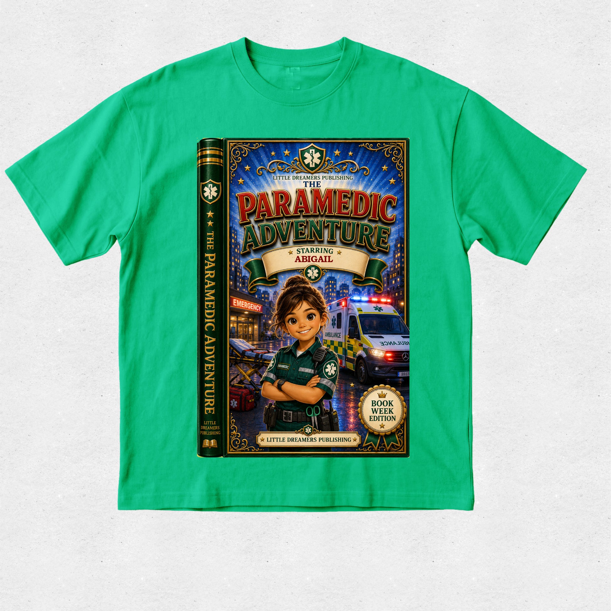 A bright green short-sleeve t-shirt with a large graphic print of a children's book titled 'The Paramedic Adventure: Starlight Ambulance'. The graphic shows a cartoon ambulance driver character in a police uniform with an ambulance in the background.