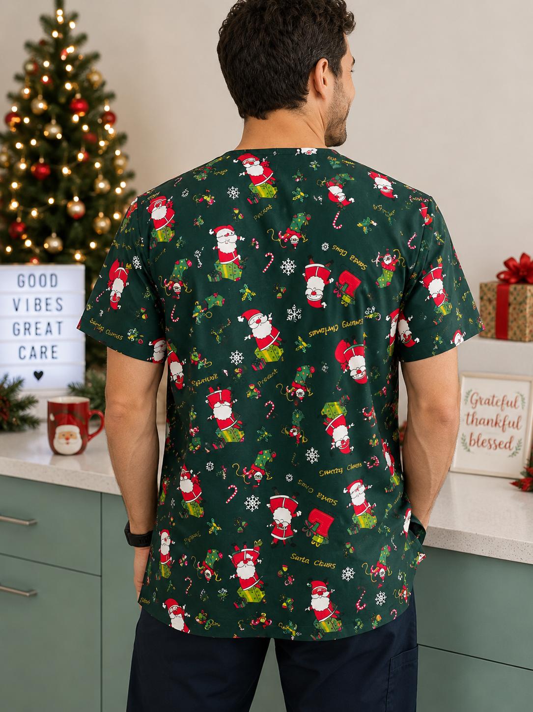 Man wearing a green Christmas-themed scrub top with Santa Claus pattern in a festive setting.