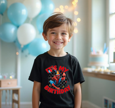 Child wearing a 'It's My Birthday' shirt with Spider-Man graphic, standing in a room with balloons and a cake.