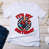 White t-shirt with Spider-Man graphic and 'It's My Birthday' text on a wooden surface with jeans and shoes.