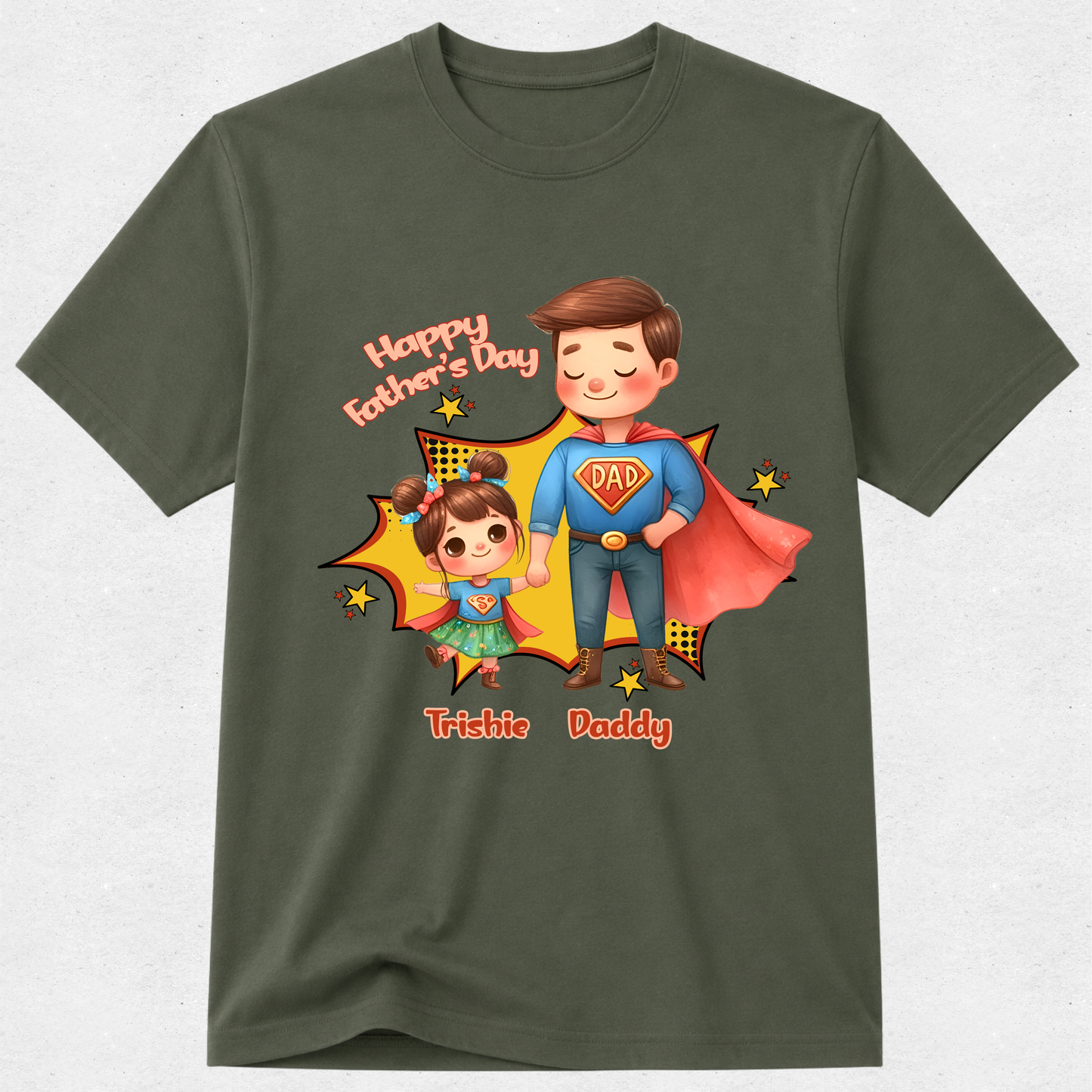 An olive green short-sleeve t-shirt with a colorful graphic on the front showing a cartoon father and daughter in superhero costumes, with 'Happy Father's Day' and 'Trishie Daddy' text.