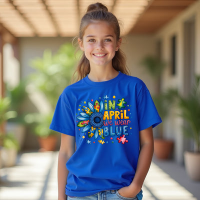 Girl wearing a blue t-shirt with colorful graphics and text, standing outdoors.