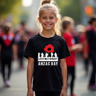 Young girl wearing a black t-shirt with an Anzac Day design, standing in a crowd.