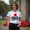Woman wearing a white t-shirt with ANZAC Day design outdoors.