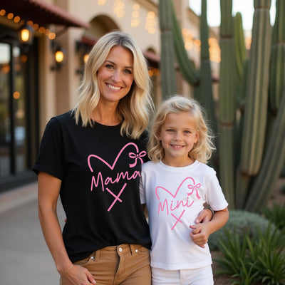 Woman and child wearing matching t-shirts with heart designs in front of cacti.