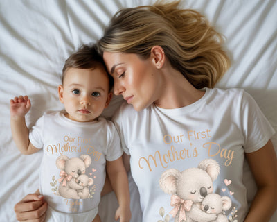 Woman and child wearing matching 'Our First Mother's Day' t-shirts with koala designs.