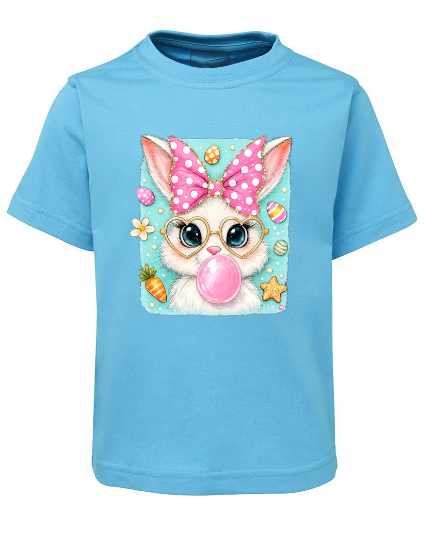 Blue t-shirt with a cartoon bunny wearing glasses and a polka dot bow, blowing a bubble, on a white background.