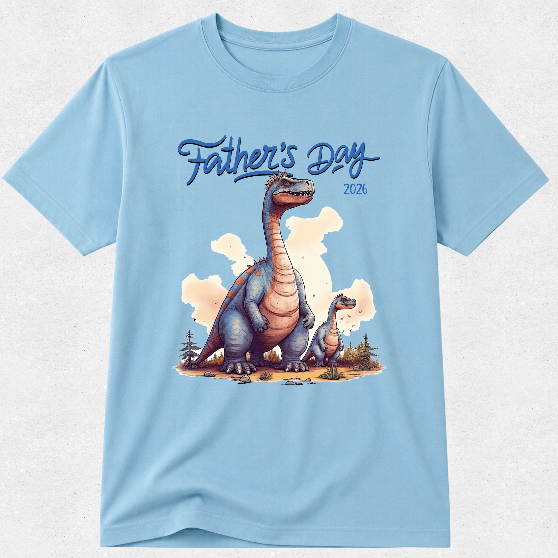 A light blue short-sleeve crewneck t-shirt featuring a 'Father's Day 2026' graphic print with an illustration of a blue and orange long-necked dinosaur and its offspring.