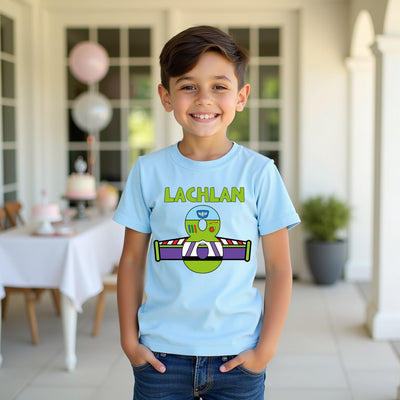 Child wearing a light blue t-shirt with a graphic design and name 'Lachlan' in an outdoor setting.