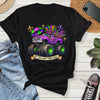 Black t-shirt with a colorful graphic and text 'Let the good times roll' on a wooden surface with jeans and sneakers.