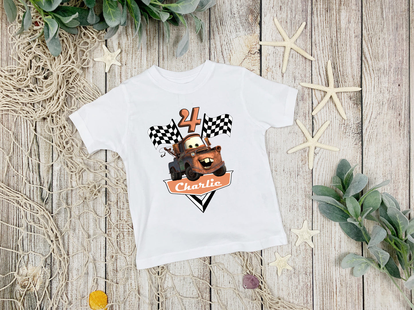 White t-shirt with a bear graphic and text on a wooden surface with decorative elements.
