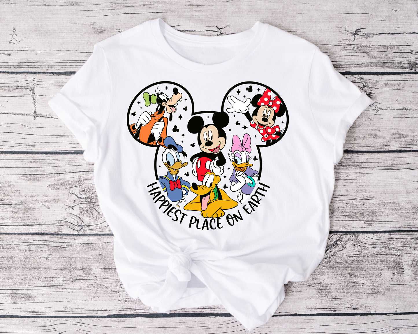 Close-up of Happiest Place on Earth t-shirt graphic featuring whimsical font and magical elements.