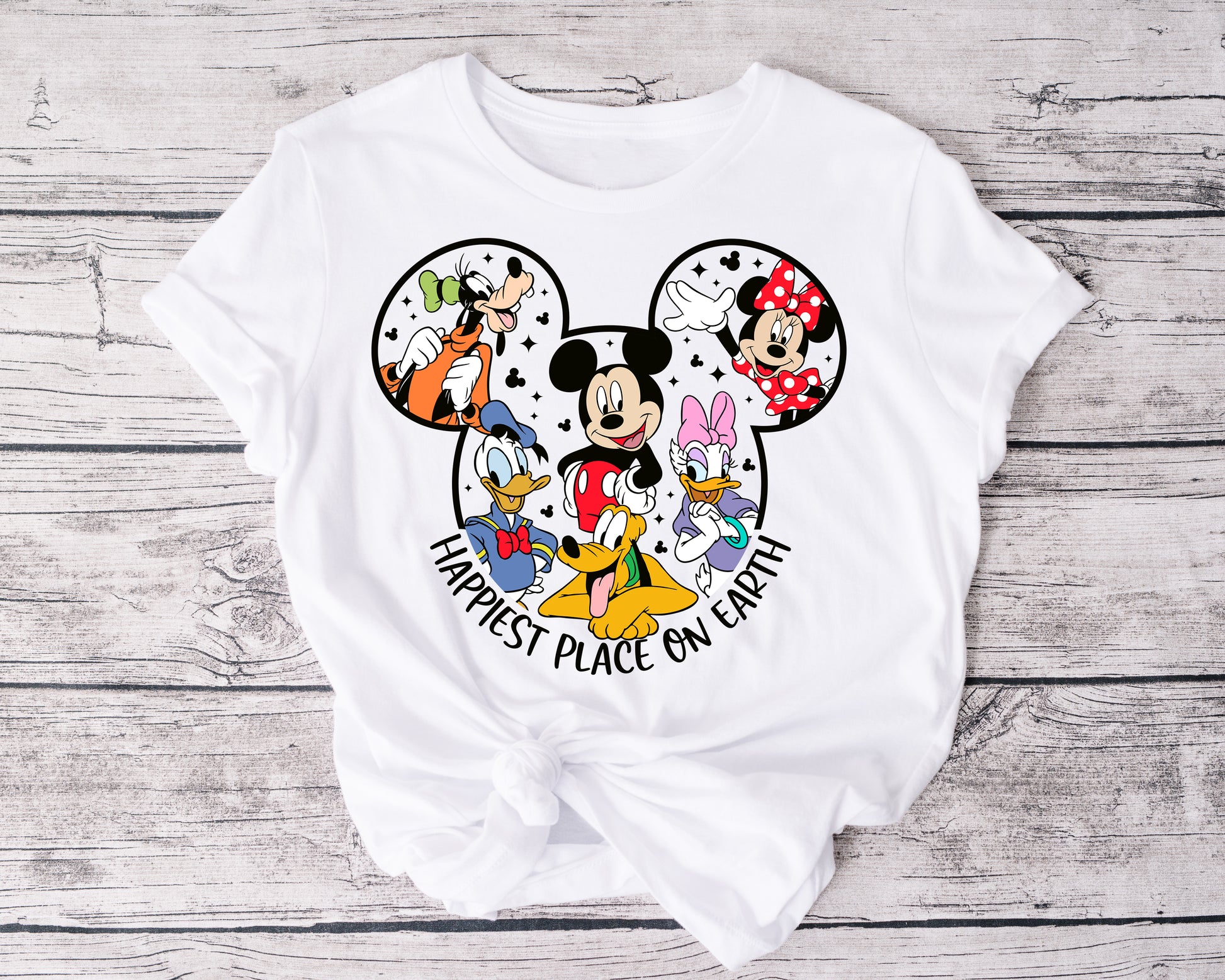 Close-up of Happiest Place on Earth t-shirt graphic featuring whimsical font and magical elements.