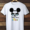 White t-shirt with a graphic design of a face with Mickey Mouse ears and 'Family Vacation 2026' text, hanging on a wooden wall.