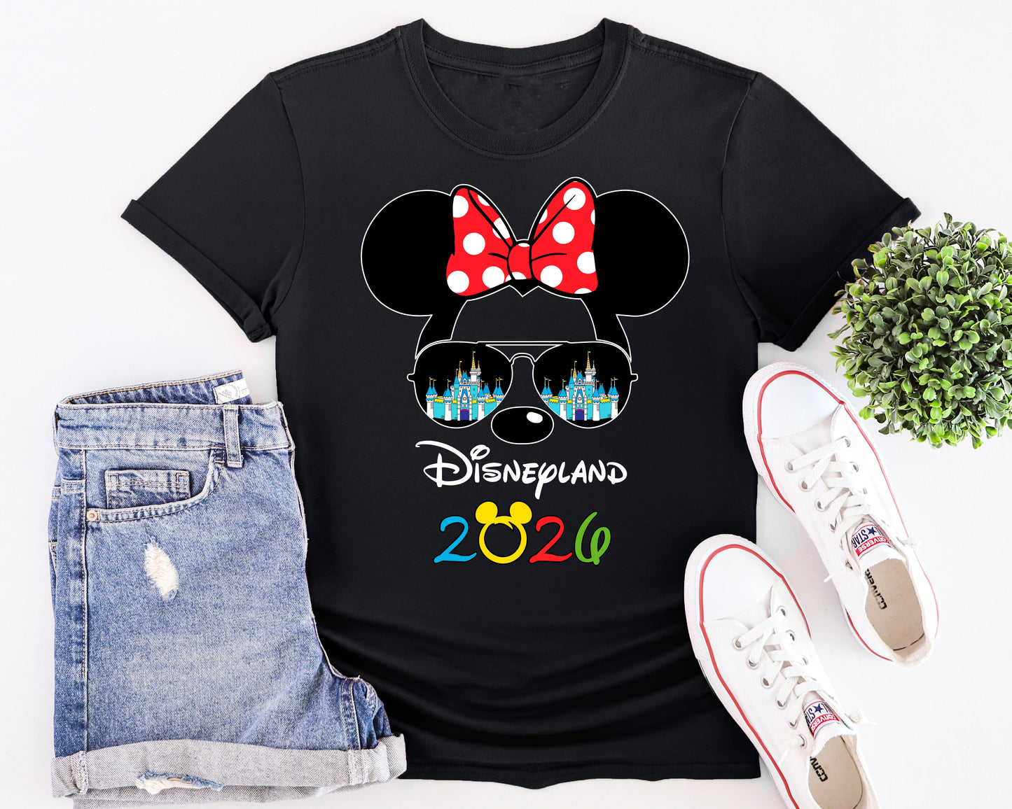 Black t-shirt with Disneyland 2026 design, shorts, and sneakers on a white background