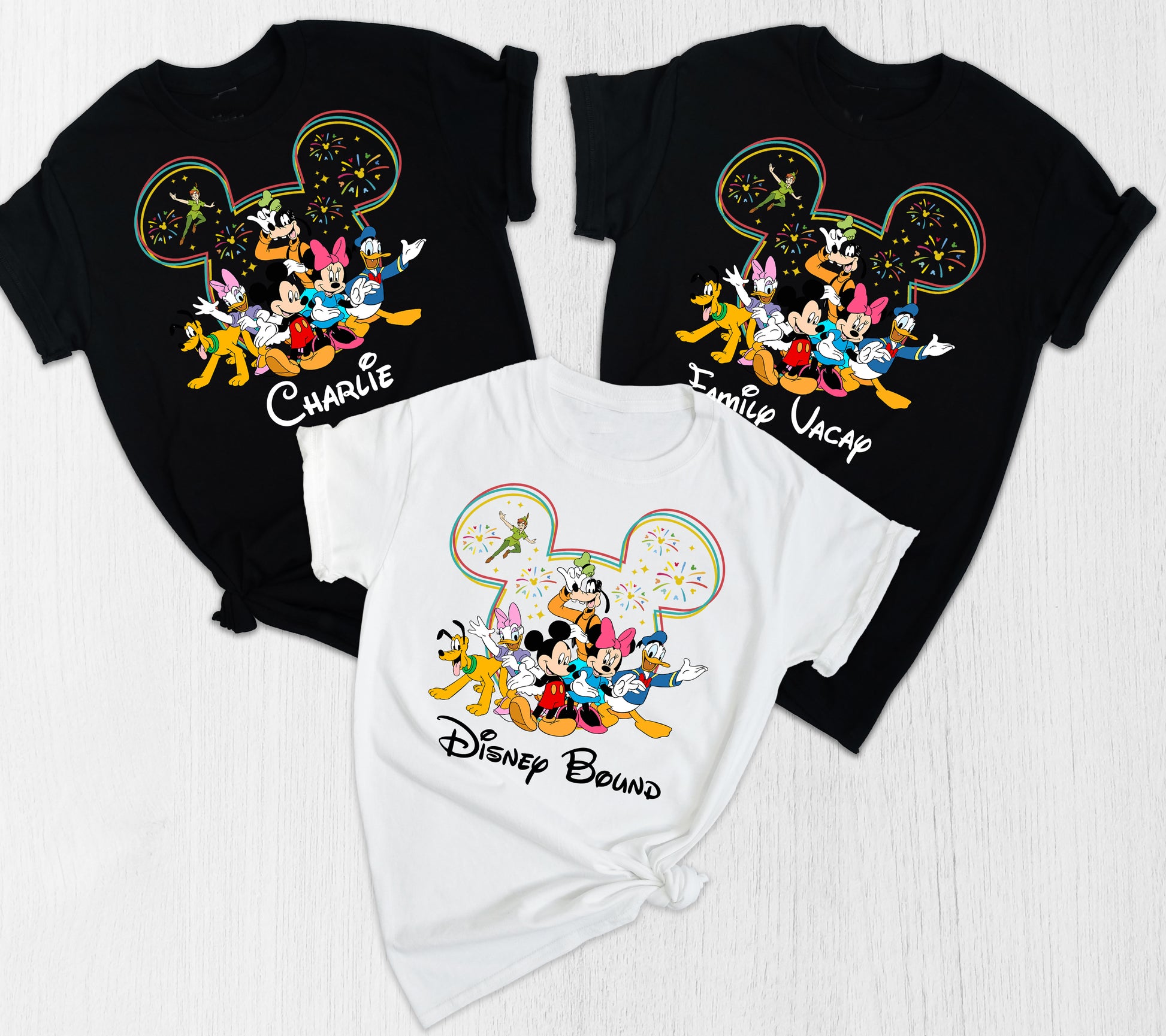 Three shirts with Disney-themed designs on a white background
