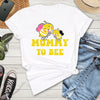 White t-shirt with 'Mummy to Bee' design on a wooden surface with jeans, sneakers, and a phone.
