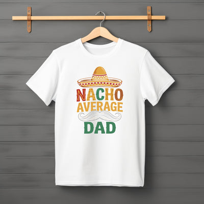 Flat lay of “Nacho Average Dad” t-shirt featuring bold text with nacho and sombrero graphic design.