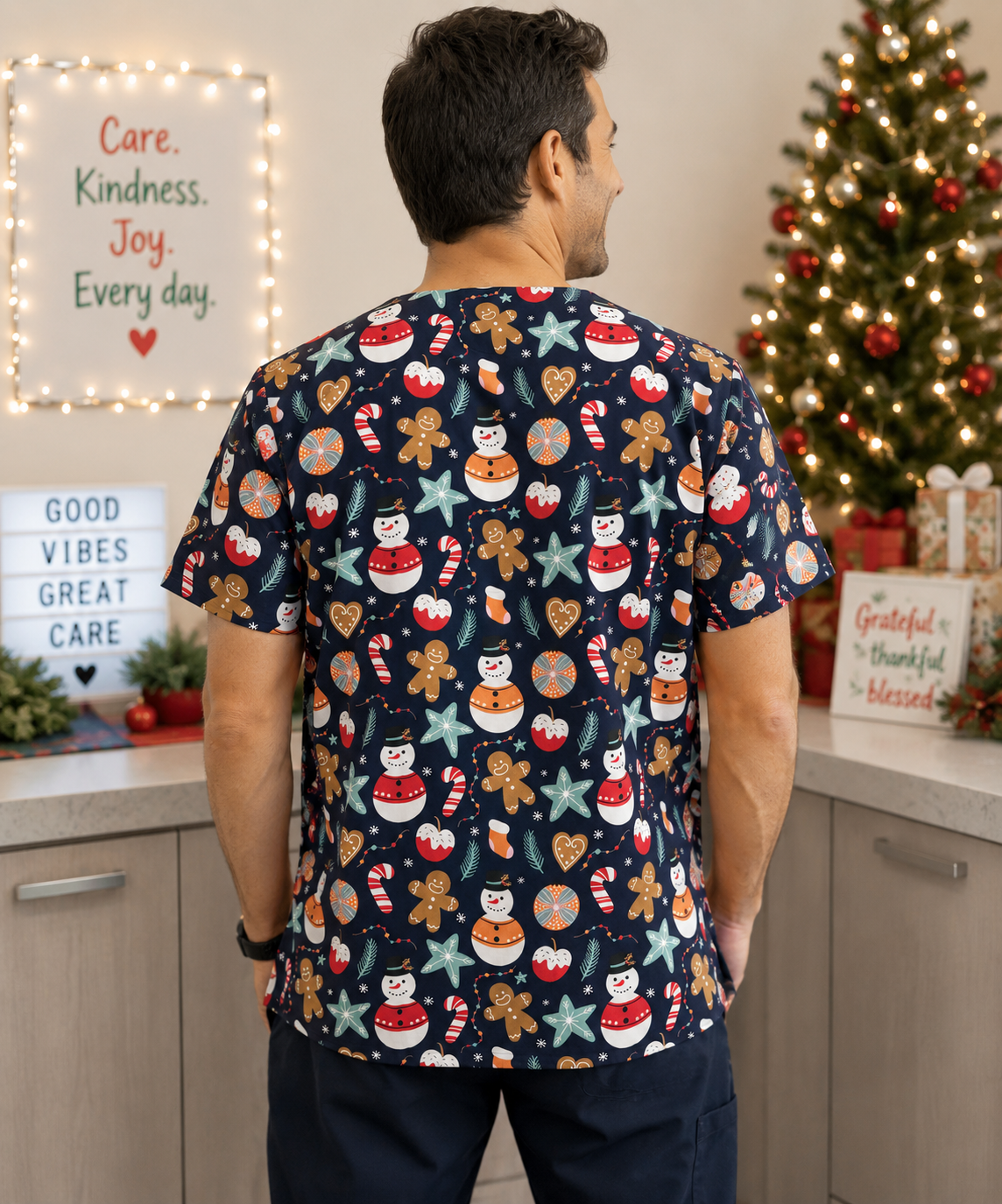 Person wearing a festive scrub top with Christmas-themed designs in a hospital setting.