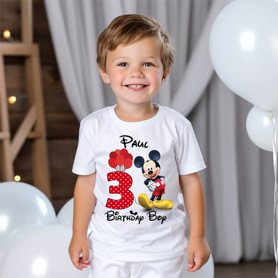 Child wearing a Disney-style mouse birthday t-shirt at a party or celebration.