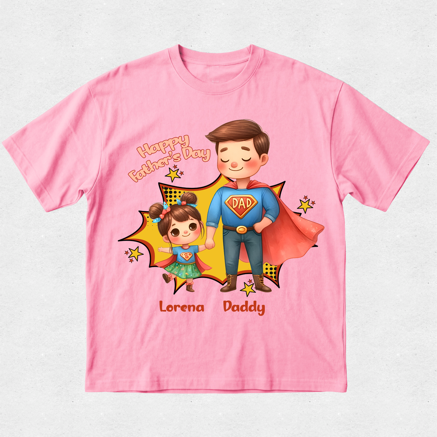 A pink short-sleeve t-shirt with a colorful cartoon graphic of a father and daughter in superhero costumes, with 'Happy Father's Day' and the names 'Lorena Daddy' printed on the front.